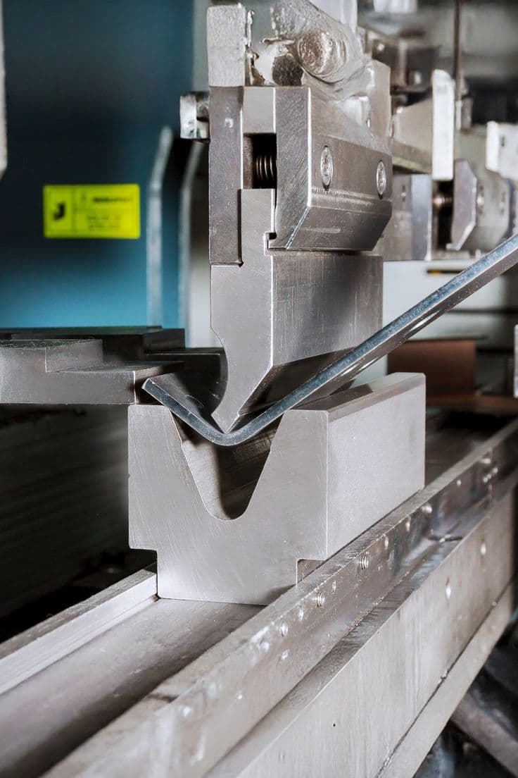 Dobladora CNC formando una varilla metálica en V